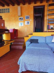 una camera con un letto blu e una parete gialla di Casa Gelsomino a Scandicci
