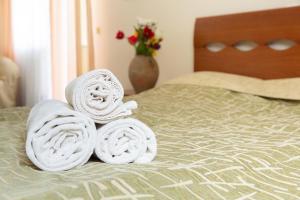 una pila de toallas sentadas encima de una cama en VILA DORULUI en Molovata Nouă