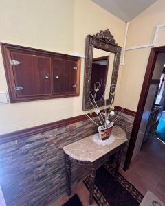 einem Spiegel und einem Tisch mit Topfpflanze darauf. in der Unterkunft O Recanto do Sossego in Mértola