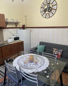 ein Wohnzimmer mit einem Tisch und einer Uhr an der Wand in der Unterkunft O Recanto do Sossego in Mértola