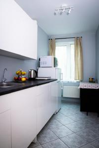 a kitchen with white cabinets and a counter top at Dream Apartment in Jelgava