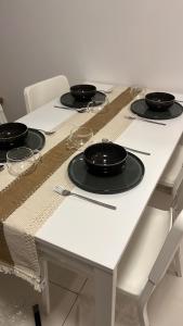 a white table with black bowls and glasses on it at Greenfield Residence - Sunway, Taylors, One Academy in Petaling Jaya
