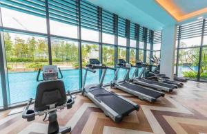 a gym with a swimming pool and treadmills at Greenfield Residence - Sunway, Taylors, One Academy in Petaling Jaya