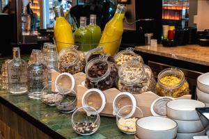 um balcão com copos e tigelas de comida e garrafas em Akeah Hotel Gran Vía em Madri