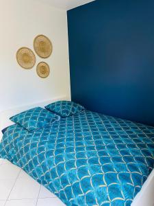 un letto in una camera da letto con parete blu di Appartement avec jardin (25min DisneyLand Paris) a Chennevières-sur-Marne