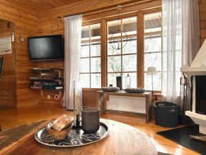 ein Wohnzimmer mit einem Kamin und einem TV in der Unterkunft Messlingen, Orrstigen 5 in Funäsdalen