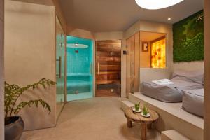a bathroom with a shower and a bed and a table at Badhotel Renesse in Renesse