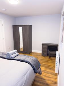a bedroom with a bed and a dresser and a desk at Entire Cozy Guest house in Galway