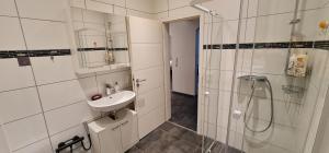 a white bathroom with a sink and a shower at RS Zimmervermietung in Euskirchen