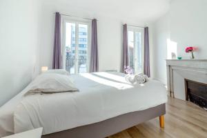um quarto branco com uma cama e uma lareira em Canebière 3 // Bel appartement climatisé avec terrasse em Marselha