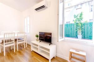 uma sala de estar branca com uma televisão e uma mesa em Canebière 3 // Bel appartement climatisé avec terrasse em Marselha