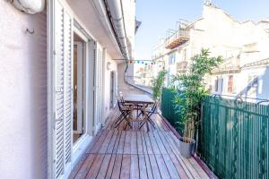 uma varanda com uma mesa num deque de madeira em Canebière 3 // Bel appartement climatisé avec terrasse em Marselha