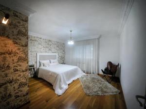 a bedroom with a white bed and a wooden floor at 0322 Apartment in Carballo in Carballo