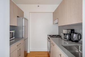 a kitchen with stainless steel appliances and gray cabinets at Chelsea 1br w doorman gym nr Union Square NYC-1240 in New York