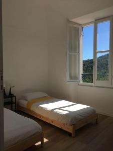 1 dormitorio con 2 camas y ventana abierta en m.a.r.e., en Calice Ligure