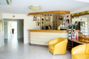 a restaurant with a counter and yellow chairs in a room at VILA DORULUI in Molovata Nouă