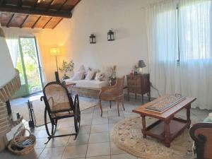 ein Wohnzimmer mit einem Sofa, einem Tisch und Stühlen in der Unterkunft Le clos Roby maison avec piscine proche du centre historique in Pézenas