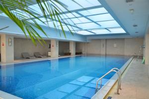 a large swimming pool with a skylight in a building at Grand Barony Xi'an in Xi'an