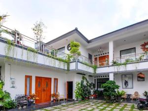 a white house with a balcony and a courtyard at Nexdeco House Homestay Syariah Solo in Solo