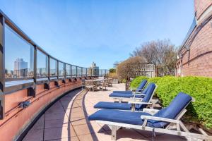 a row of blue lounge chairs on a balcony at UES 1BR w Gym WD nr Central Park NYC-1296 in New York