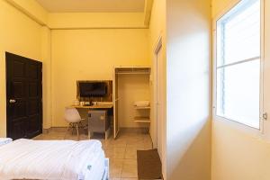 - une chambre avec un lit et un bureau avec un ordinateur dans l'établissement Joox B - Serviced Apartment, à Betong