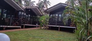 a building with a hose attached to the grass at Seascape by Sand Sapphire in Canacona