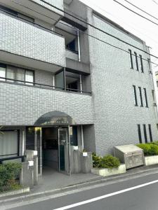 um grande edifício de tijolos com uma porta em frente em ラフォレ１０１　新宿から13分のくつろげるお部屋 em Tóquio