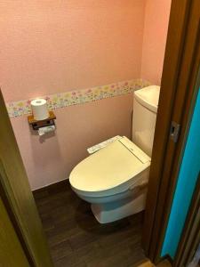 a bathroom with a white toilet in a pink room at ラフォレ１０１　新宿から13分のくつろげるお部屋 in Tokyo