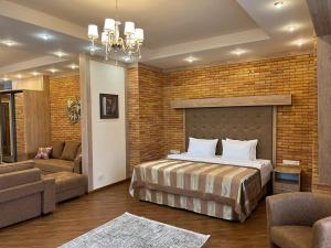 a bedroom with a bed and a brick wall at CITY STAY Апарт-Отель Алматы in Almaty