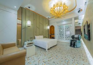 - une chambre avec un lit, un canapé et un lustre dans l'établissement Feng Cai Motel, à Yuanlin