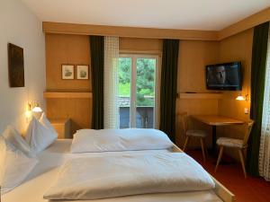 a hotel room with a bed and a window at Villa Erika - NEW Luxury Alpine Apartments from December 2026 in Sesto