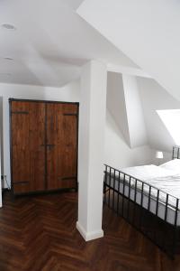 a bedroom with a bed and a wooden cabinet at Villa von Schönermarck in Falkensee