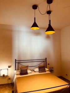 um quarto com uma cama com três luzes por cima em Sicilia Vacation em Trapani