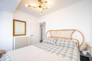 1 dormitorio con 1 cama con cabecero de madera en VENTURA Y LA BARAGAÑA (Vivienda turística en Candás), en Candás