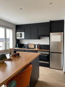 a kitchen with stainless steel appliances and a wooden table at Chambre Cavaignac in Calais