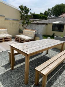 a wooden picnic table and benches on a patio at Chambre Cavaignac in Calais