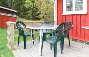 Hindås的住宿－Lovely Home In Hrryda With Kitchen，甲板上的一张桌子和四把椅子