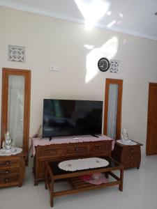 ein Wohnzimmer mit einem Flachbild-TV und einem Tisch in der Unterkunft umah kampung bendul in Penebel