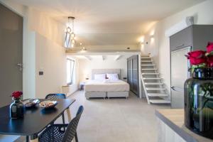 a bedroom with a bed and a table and chairs at Manthos Beachfront Apartments in Laganas