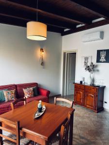 uma sala de estar com uma mesa de madeira e um sofá em Sicilia Vacation em Trapani