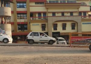 ein weißes Auto, das vor einem Gebäude parkt in der Unterkunft Hotel Moomsie Itanagar Arunachal Pradesh in Itānagar