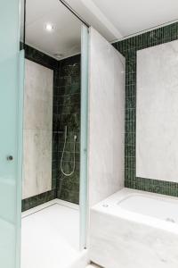 ein Badezimmer mit einer Dusche und einer weißen Badewanne in der Unterkunft Hotel Villa Real, a member of Preferred Hotels & Resorts in Madrid