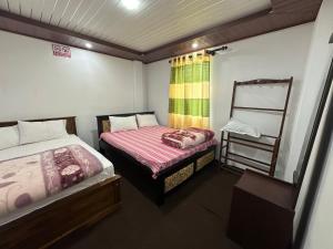a small bedroom with two beds and a ladder at Sushi guest - mini in Nuwara Eliya