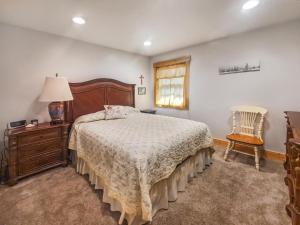 1 dormitorio con 1 cama, vestidor y silla en Anchors Away Cottage on Big Spirit Lake, en Orleans