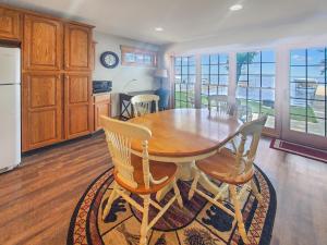 cocina con mesa de comedor de madera y sillas en Anchors Away Cottage on Big Spirit Lake, en Orleans