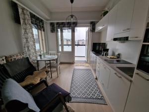 a kitchen and living room with a couch and a table at New Center Sity Home in Kuopio