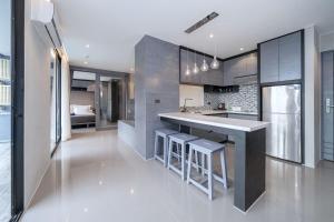 a kitchen with a counter and some stools in it at Tropics Kamala 2BR Apartment CTG B605-6 in Kamala Beach