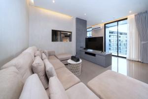 a living room with a large couch and a flat screen tv at Tropics Kamala 2BR Apartment CTG B605-6 in Kamala Beach