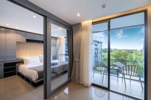 a bedroom with a bed and a balcony with a table at Tropics Kamala 2BR Apartment CTG B605-6 in Kamala Beach +25 photos