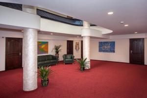 een lobby met een rode loper en stoelen en pilaren bij Tauras Center Hotel in Palanga